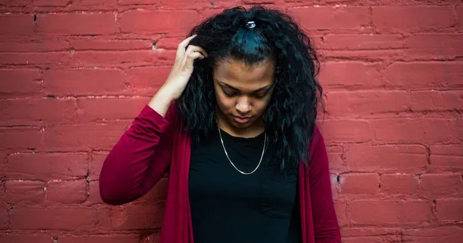 A lady with her head down looking sad and uncertain