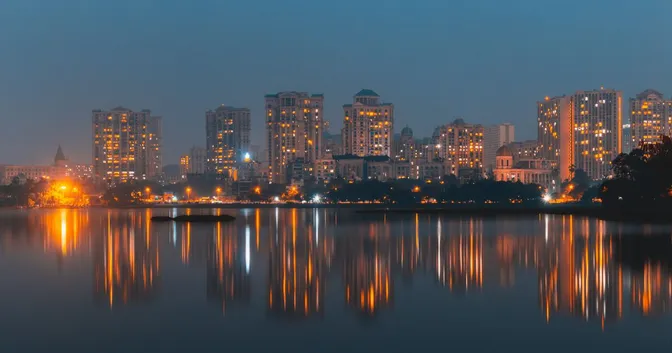 Citycape in India showing tall buildings with a fuzzy reflection in the river below