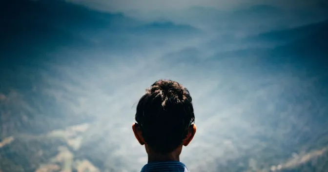 A young many looking at distant mountains