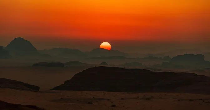 A photo of a mountain range with the sun rising in the distance reminding us of the beginning of creation.